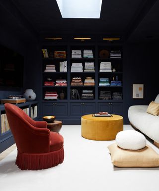 best blue paints, dark blue living room with bookcase, cream couch and rug, rust armchair