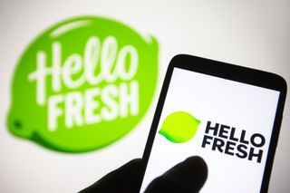 HelloFresh logo displayed on a smartphone with branding and logo on white background