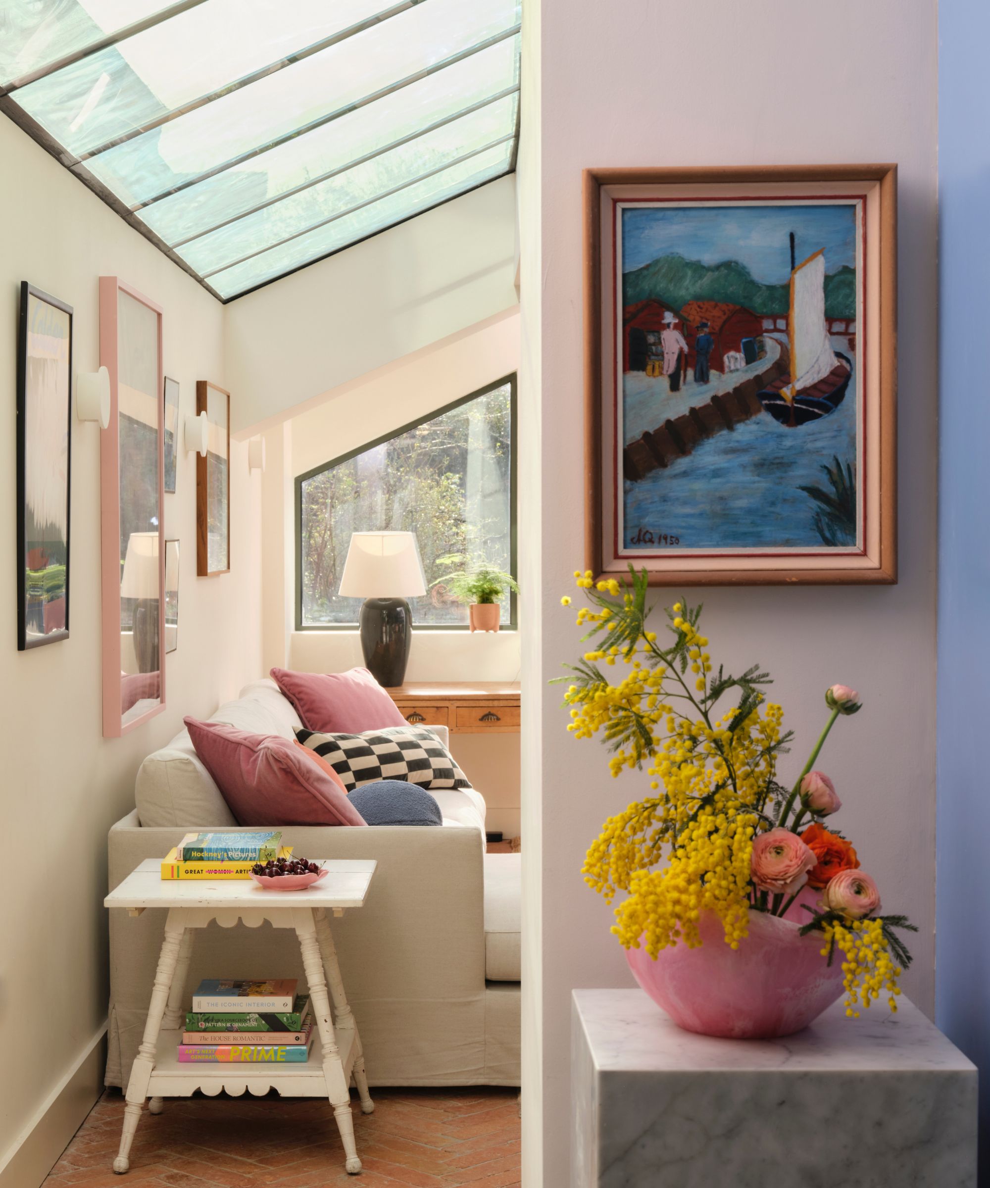 The view from a colorful kitchen into a living room featuring a glass roof
