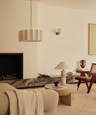 cream living room with ceiling, table and wall light