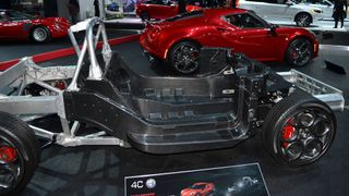 Carbon fiber tub chassis (foreground) and complete car (background) of Alfa Romeo 4C.