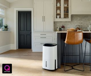 A white portable dehumidifier positioned next to a kitchen island