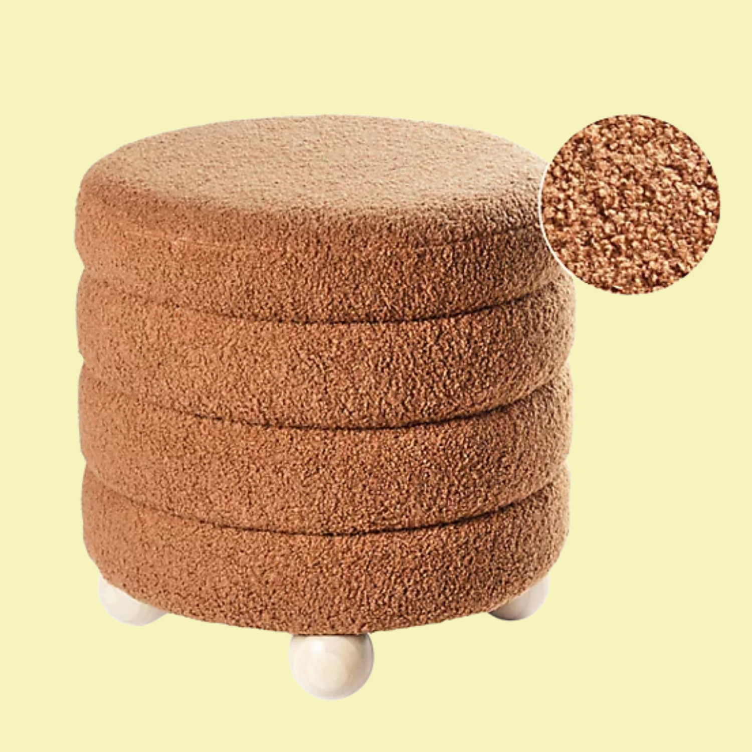 A stacked clay boucle ottoman with white wood bobbin feet