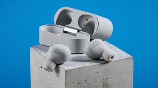 Sony WF-1000XM6 earbuds photographed in front of a blue background