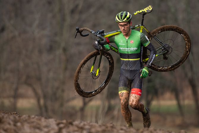 Curtis White is forced to carry his bike in the muddy conditions
