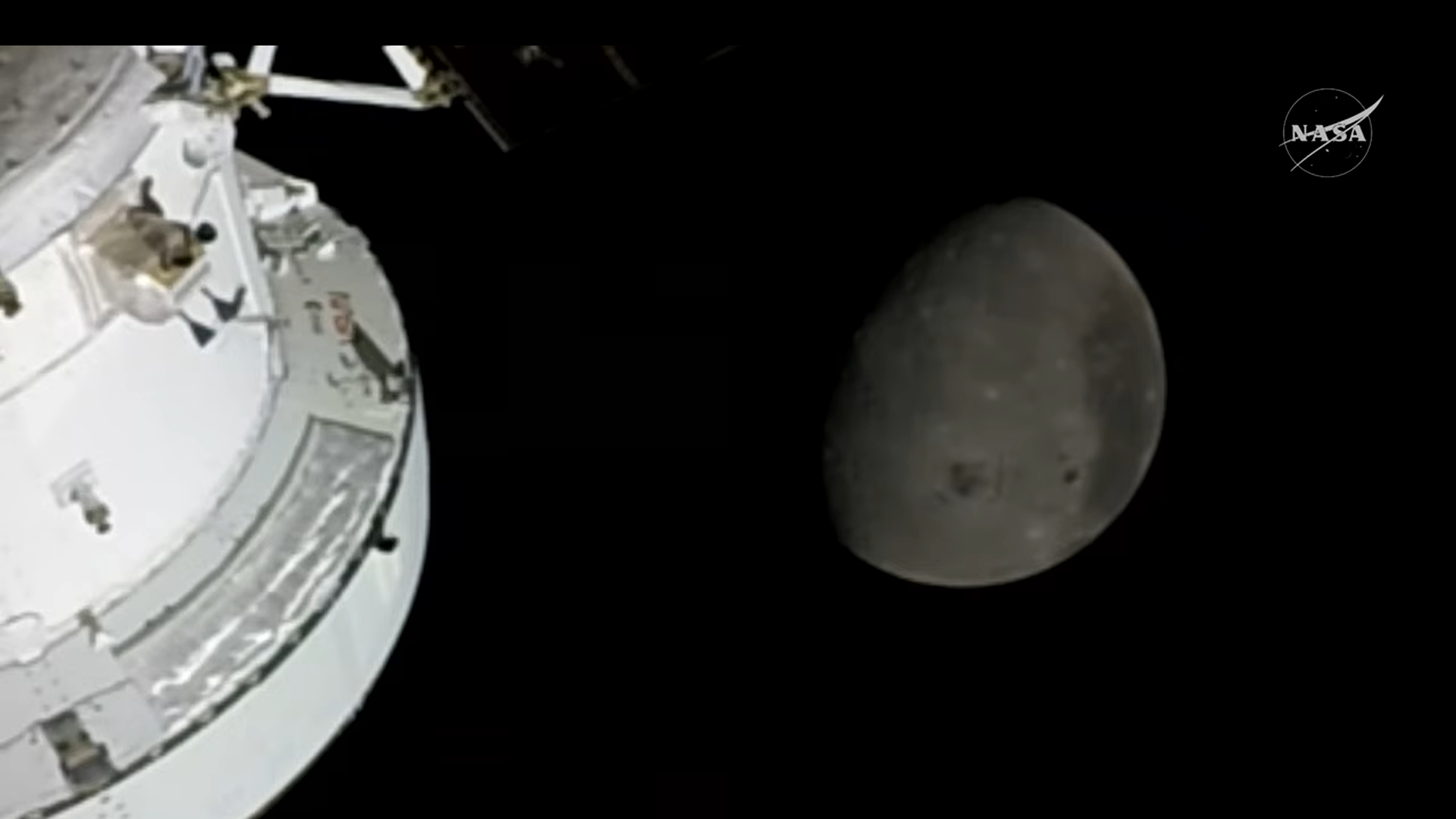 A white spacecraft is seen in the bottom left of this image where a gray sphere of the moon is seen in the center of the image