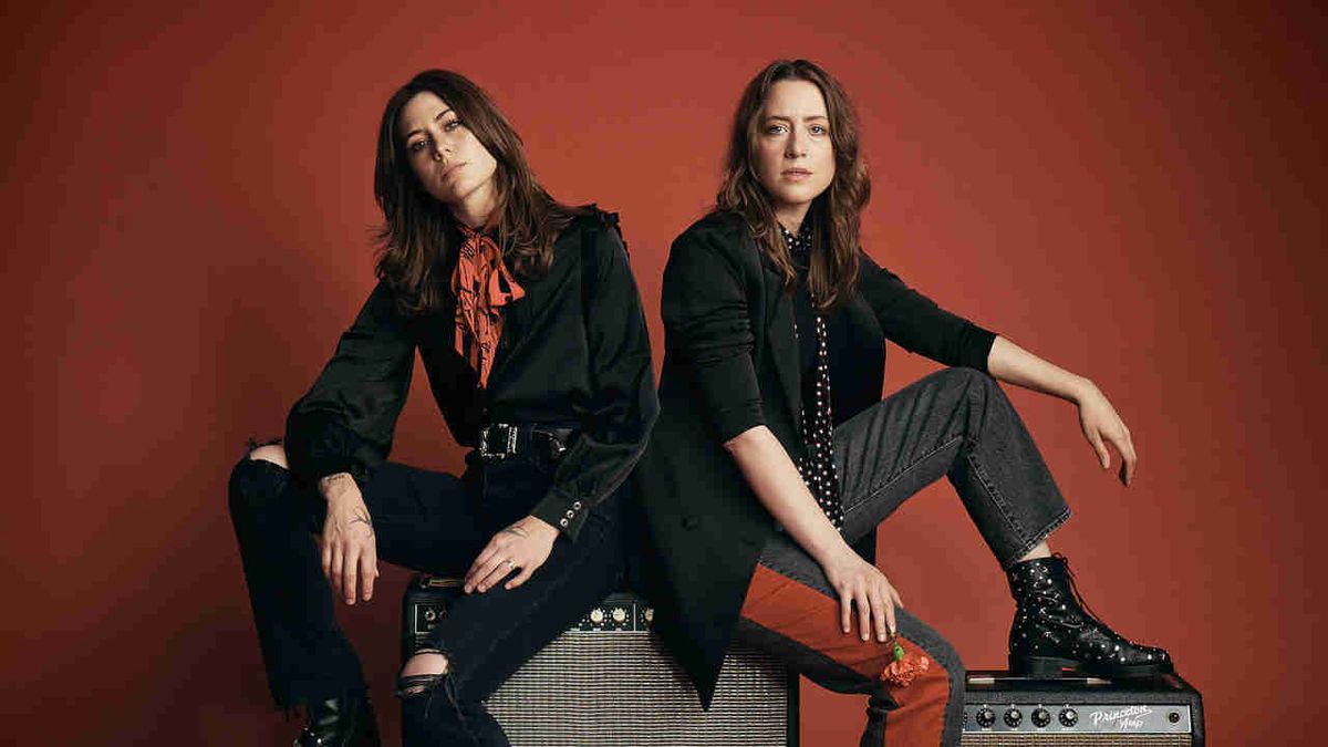 Larkin Poe’s Rebecca and Megan Lovell posing for a photograph sitting on amps