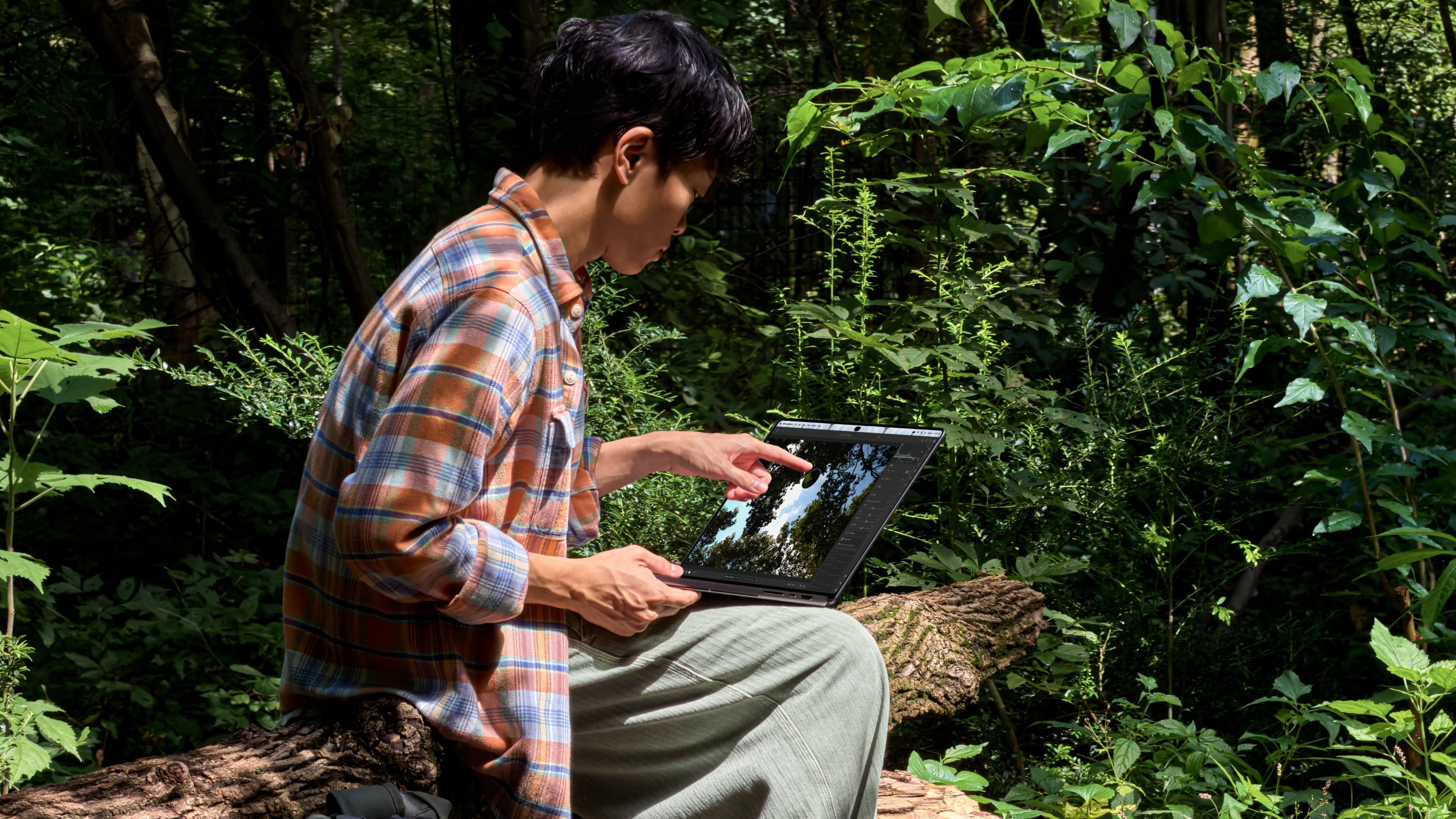 A person touching the MacBook Pro with PROLED XDR Display