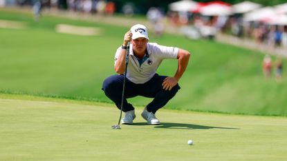 Caleb Surratt crouches down behind a putt during LIV Golf Indianapolis 2026