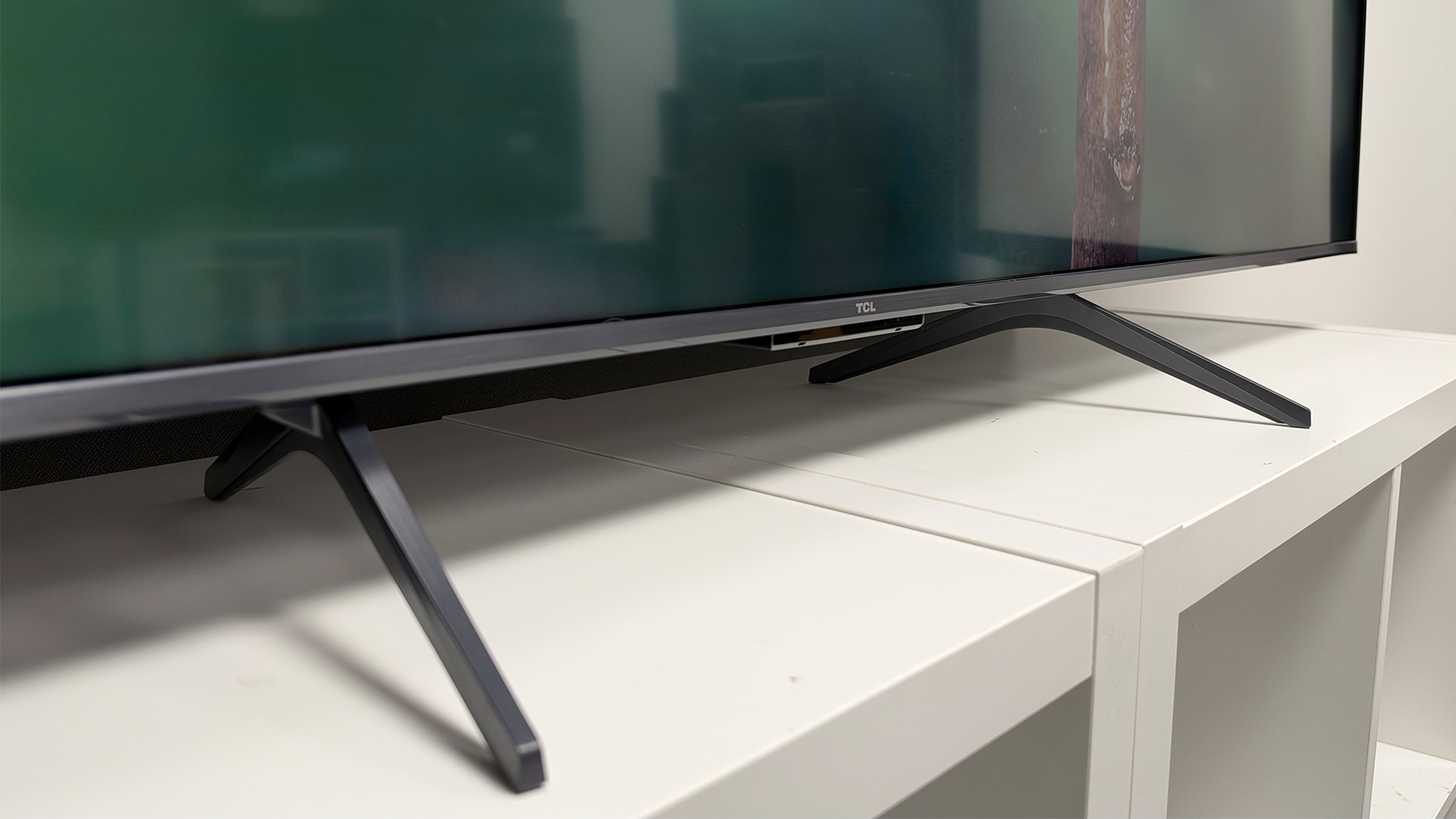 TCL P8L TV on white wooden shelving unit, detail of feet