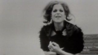 Gilda Radner looking at the camera in a dress in "La Dolce Gilda" on SNL