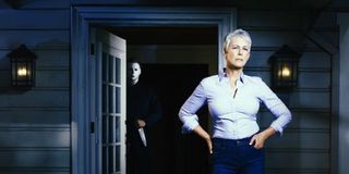 Jamie Lee Curtis stands in front of Michael Myers in Halloween