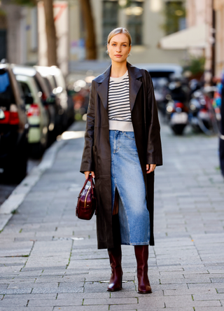 Marlies-Pia Pfeiffhofer, wearing a white pullover with black stripes by Veronica Beard, a blue jeans skirt by Mango, a dark brown trench coat by Cos, dark brown boots by Cos and a dark brown bag by Miu Miu, during a streetstyle shooting on October 31, 2022 in Munich, German