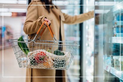 Woman carrying shopping basket in supermarket
