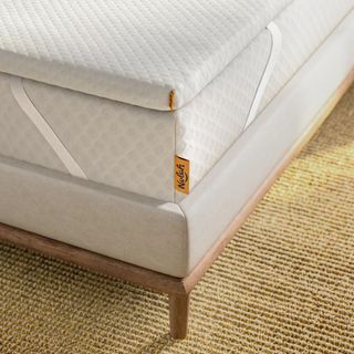 A close up of a Nolah mattress topper on the corner of a bed