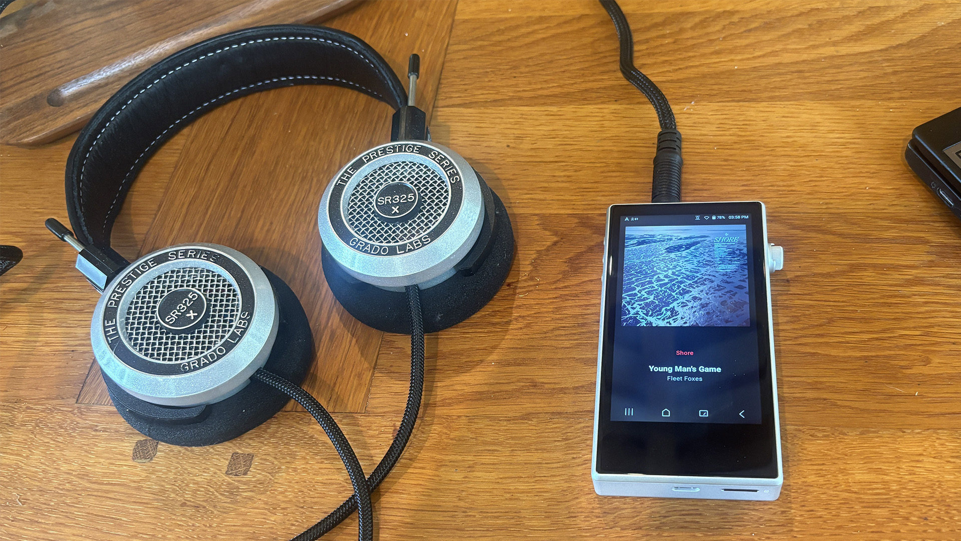 Astell &amp;amp; Kern PD5 portable music player on wooden table plugged into Beyerdynamic headphones, playing on PD5 is Fleet Foxes