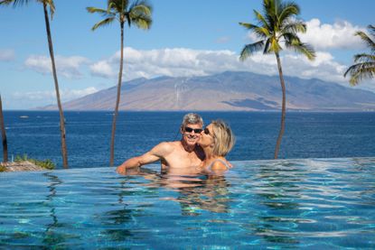 2R4X8FR Couple enjoying the infinity pool at The Four Seasons Resort; Wailea, Maui, Hawaii, United States of America