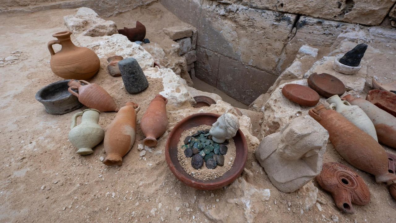 A selection of artifacts including vases and urns, coins, and a bust