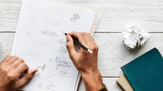 Art techniques: person holding pencil with notebook