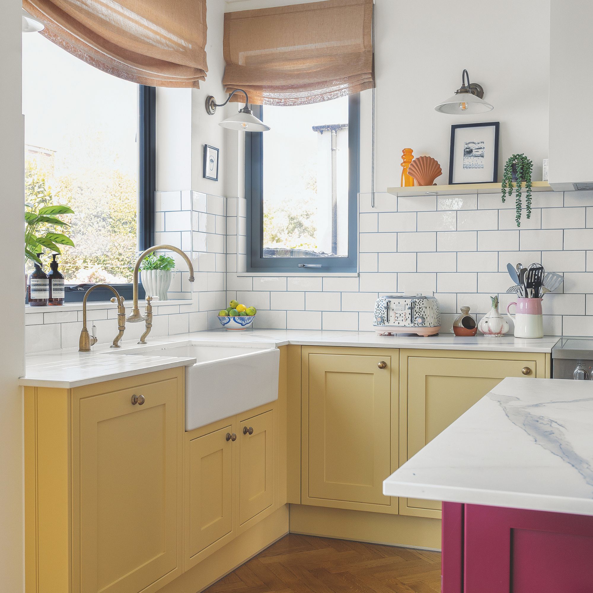 Kitchen with yellow cabinets and a white worktop, and metro tiles on the wall