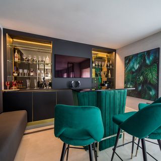 bar area with black counter with turquoise chairs