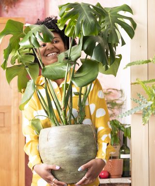 Woman carrying large houseplant