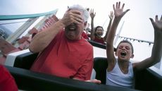 A man closes his eyes on a roller coaster