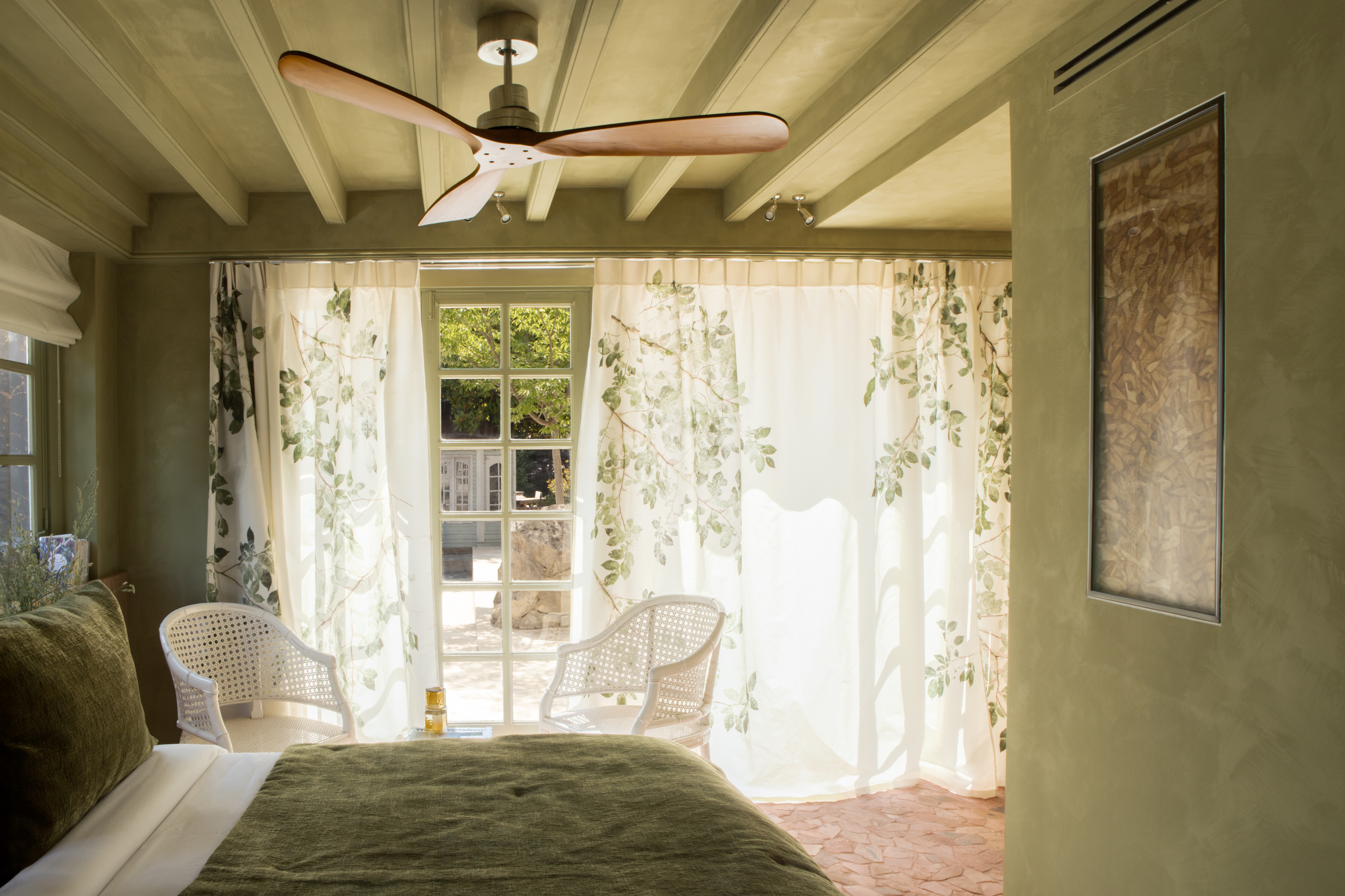 A whimsically designed hotel boasts richly layered interiors characterized by hand-drawn, fantastical mural motifs, earthy and pastel shades, and shapely furniture.