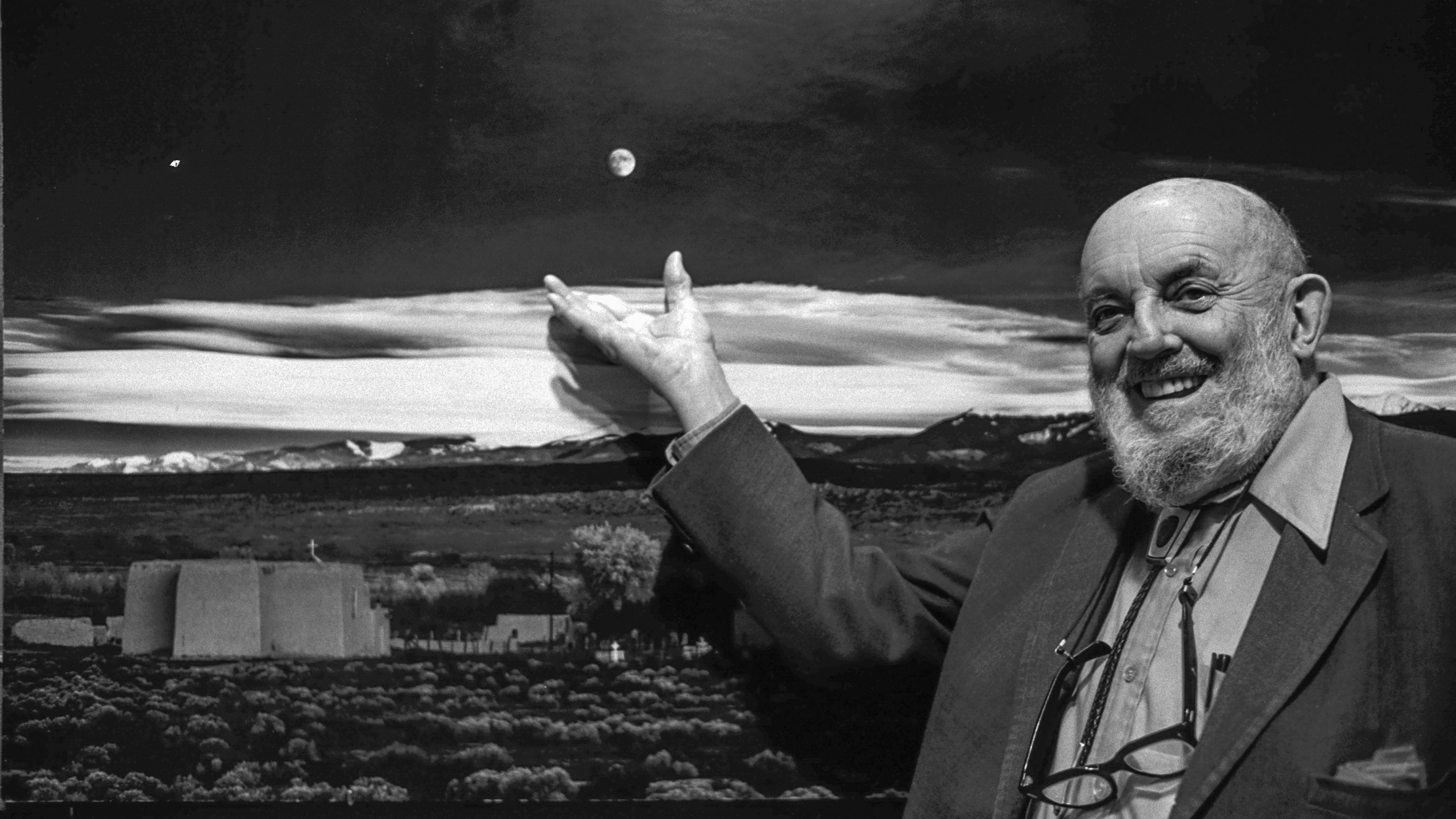 Ansel Adams at a party celebrating the fortieth anniversary of his photograph "Moonrise Over Hernandez, N.M." He stands next to a large print of the photograph, pointing to the moon. (Photo by Roger Ressmeyer/Corbis/VCG via Getty Images)