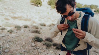 best base layer: pictured here, a hiker doing up his hiking backpack straps