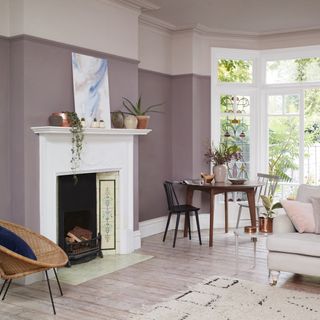 living area with pink wall and wooden floor and fireplace and armchair