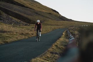 Image shows lone cyclist on a training ride in Wales