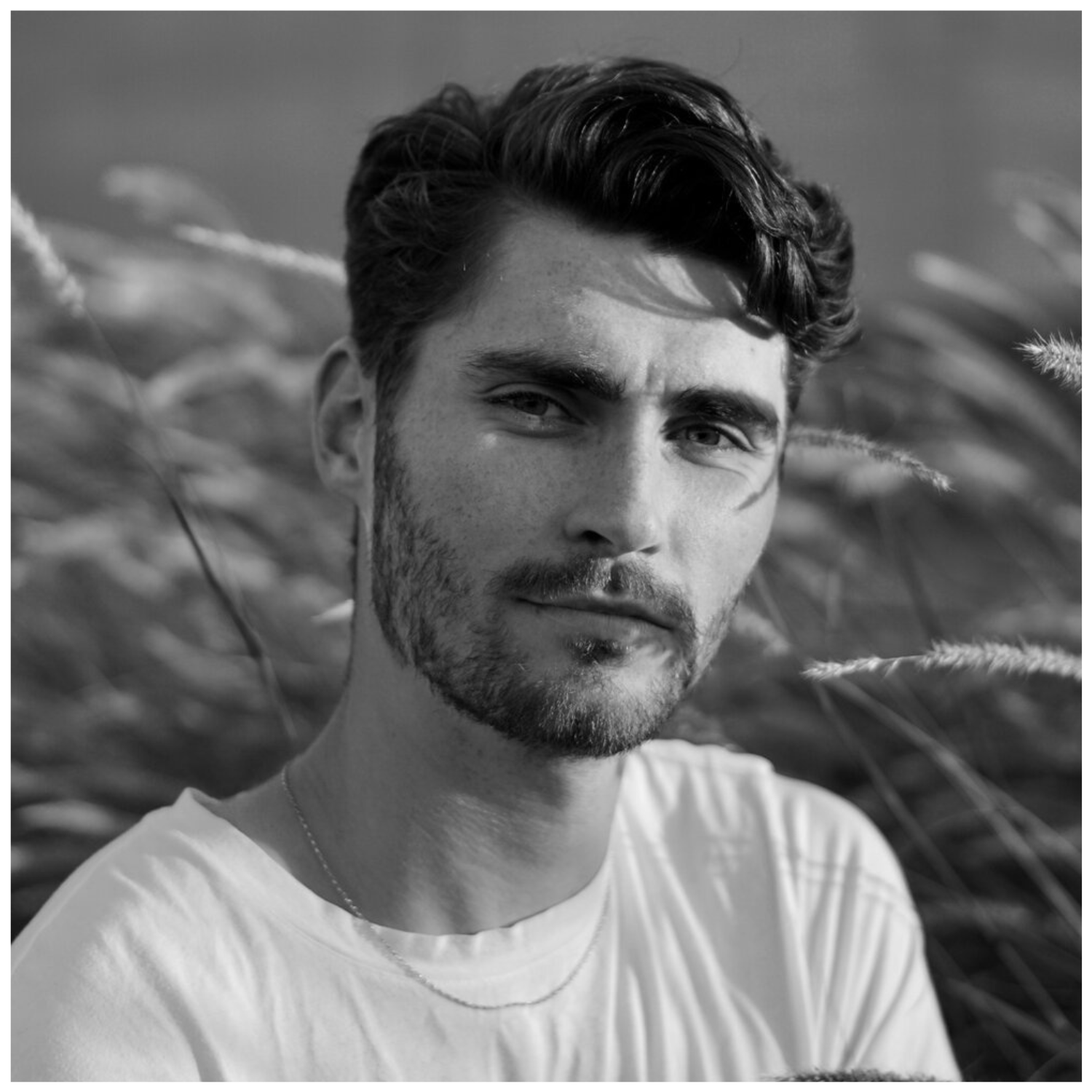 A headshot of garden designer Max Parker-Smith in black and white