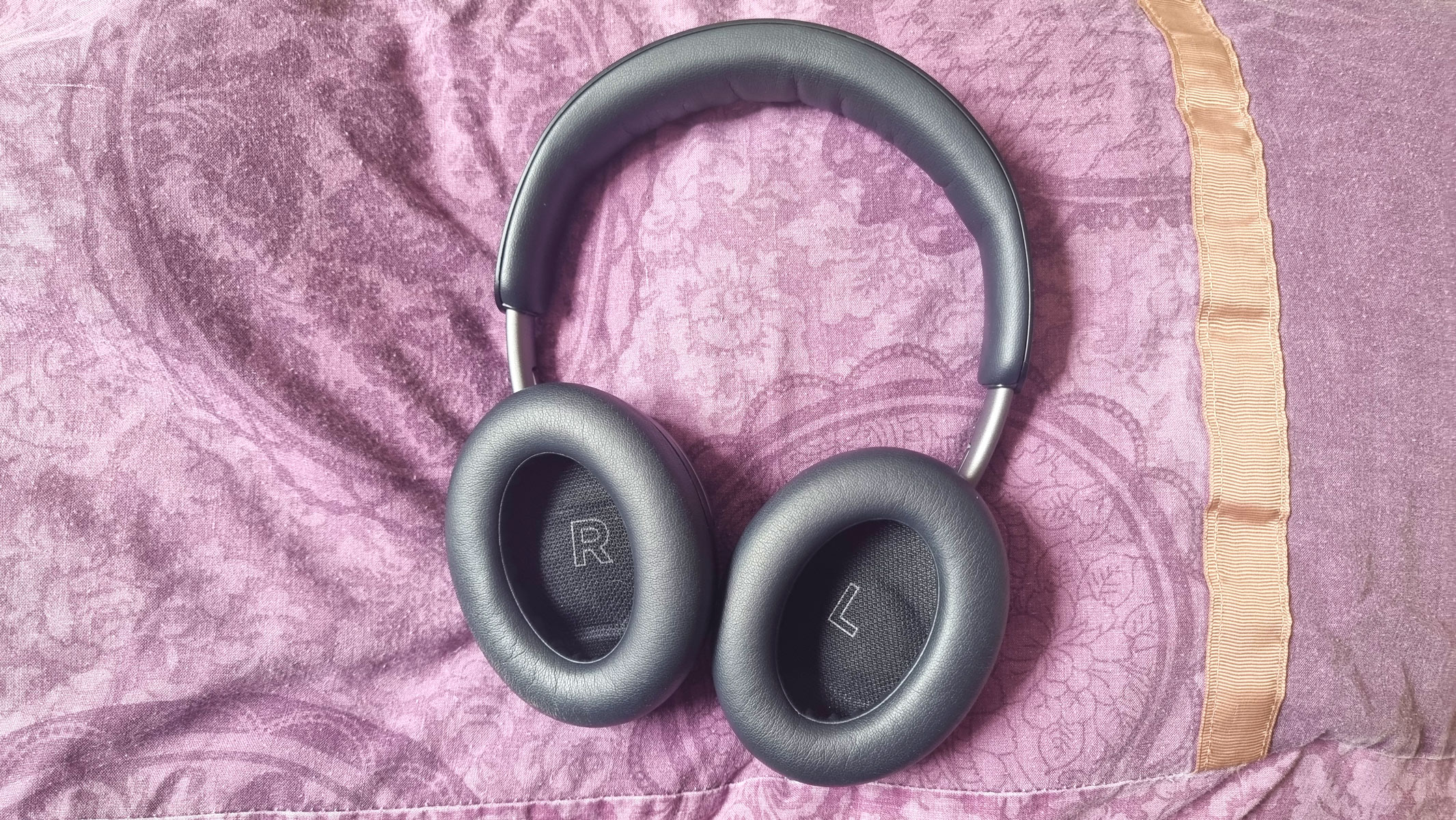 Bose QuietComfort headphones laid out on a purple pillow