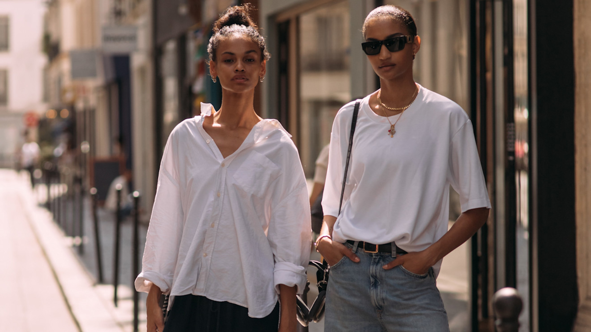 two fashion week attendees wearing updo hairstyles and white tops