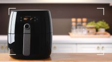 black air fryer on a kitchen counter, with kitchen appliances to the right to support an article questioning how much does it cost to run an air fryer