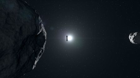 a cube-shaped spacecraft wrapped in foil floats past two irregularly shaped rocks covered in craters