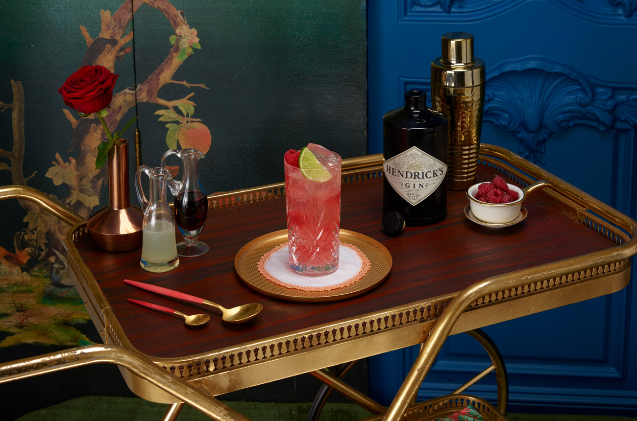 a cocktail and bottle of gin on a drinks trolley