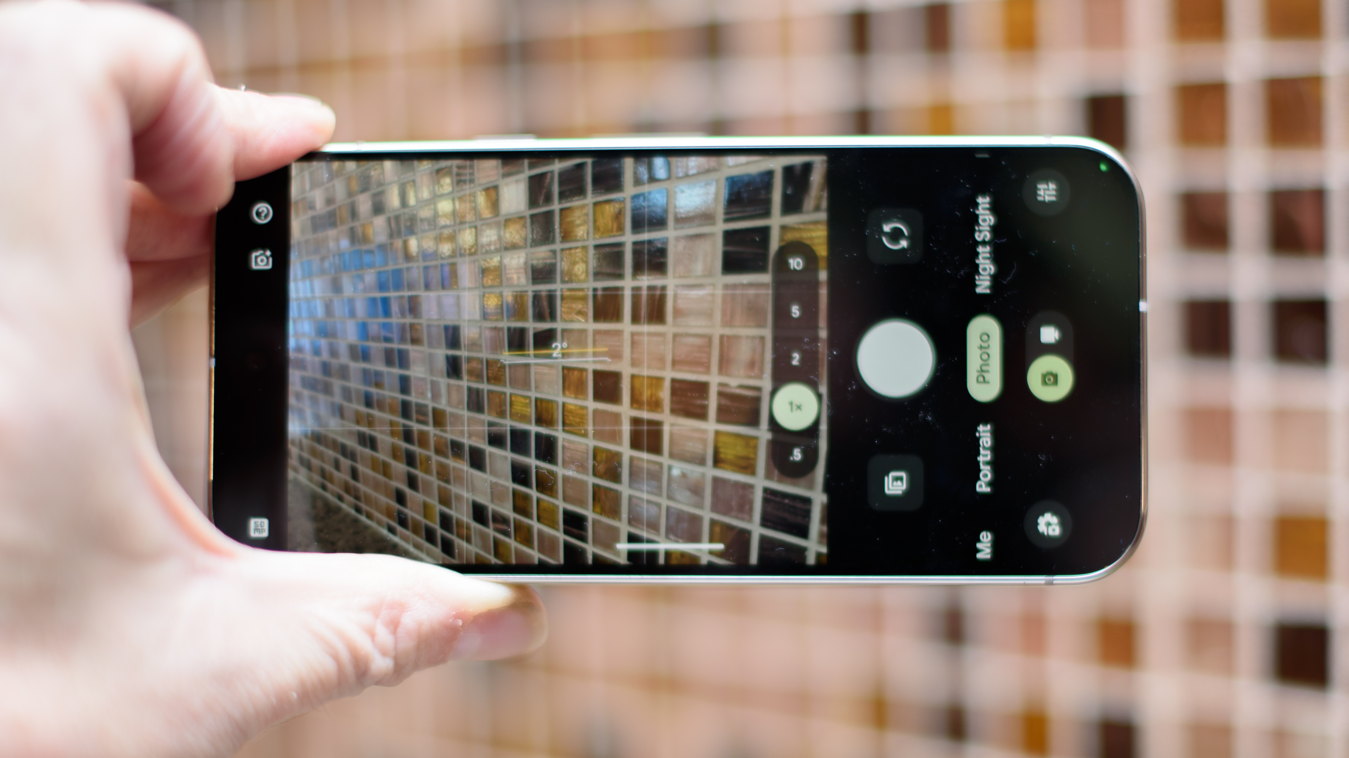 Google Pixel 10 Pro in Jade with checkered tile backsplash background