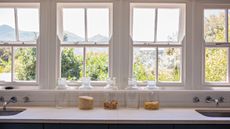 A longbank of open kitchen windows above a counter with jars of dried goods