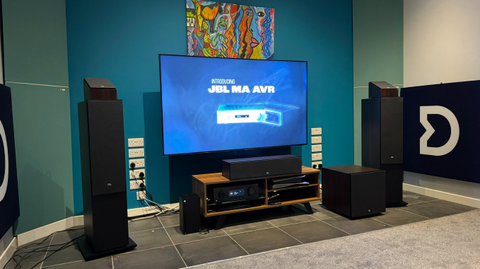 A TV on a media unit with speakers on either side