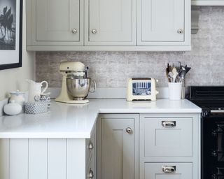 pale blue kitchen with white countertops and toaster and kitchenaid