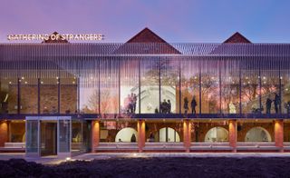 The Whitworth at the University of Manchester in the evening. You can see groups of people through the windows