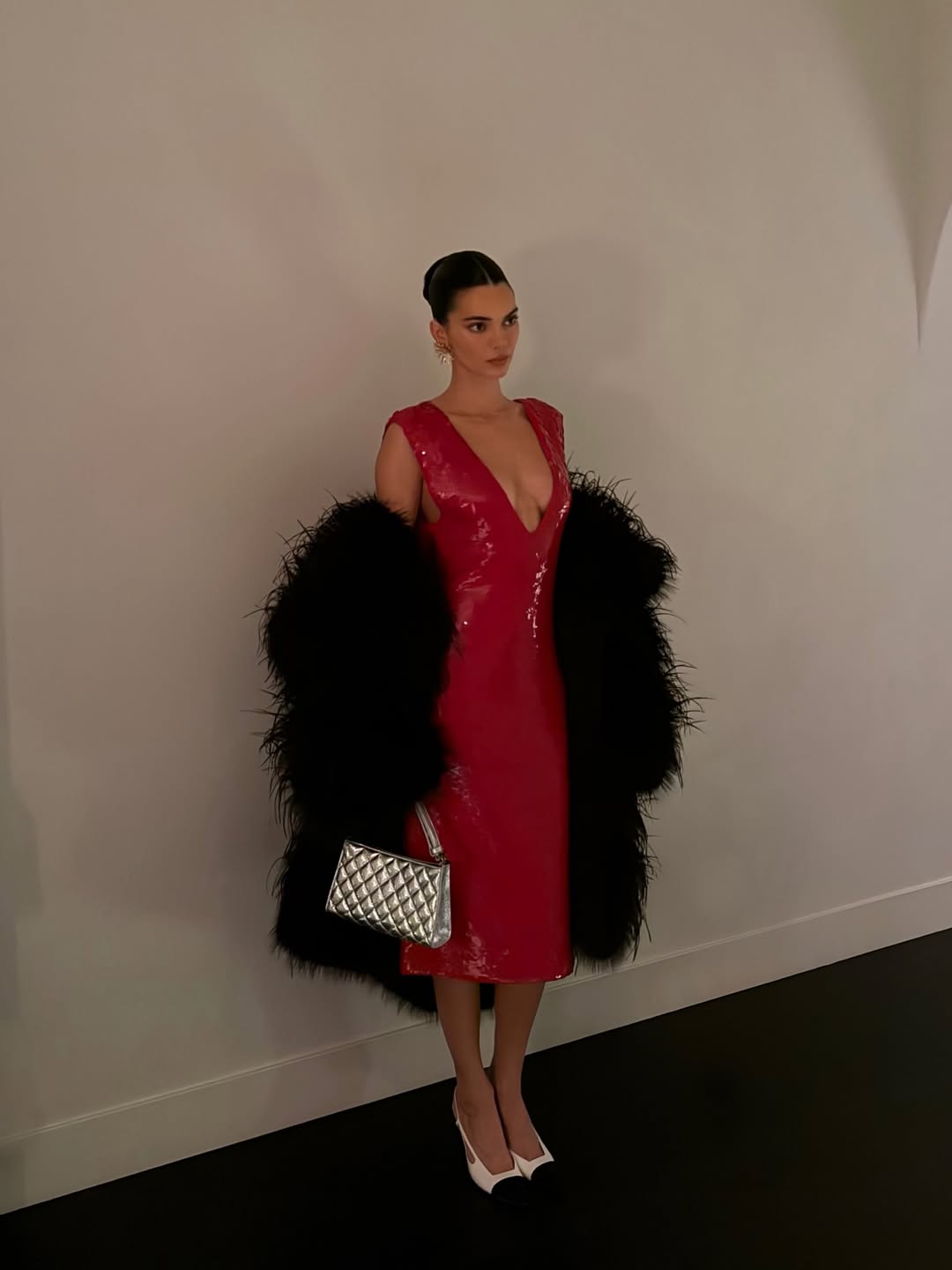 Kendall Jenner wears a Chanel runway outfit and carries a silver holiday collection quilted shoulder bag