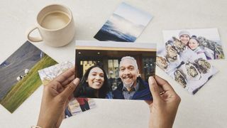 Hands holding a photo of a smiling man and women