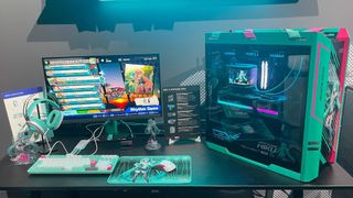 A showroom desk featuring many peripherals and bits of hardware from the Asus x Hatsune Miku collaboration.