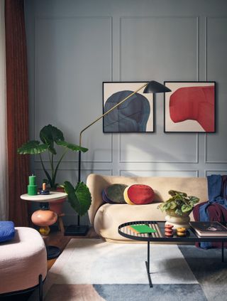 Living room with pale grey walls, pale yellow sofa, and punches of red, dark blue and bright green