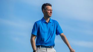 A golfer wears the Nike Dri-Fit Tour Solid Polo Shirt in blue