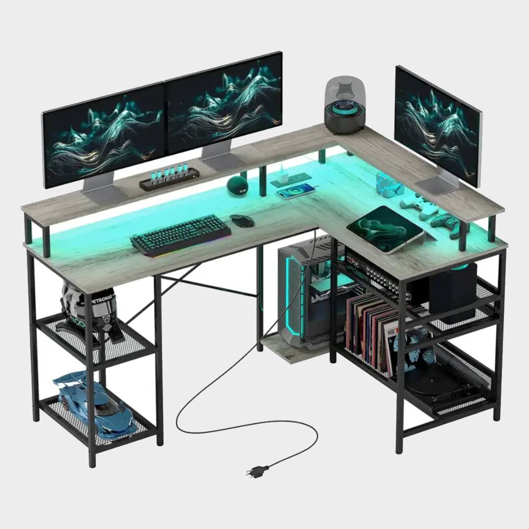 Homcom L-shaped gaming desk with books on shelves, keyboard and mouse on top alongside monitors, and surface illumated by blue RGB lights.