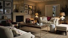 cosy living room with low lighting and white sofas and neutral decor 